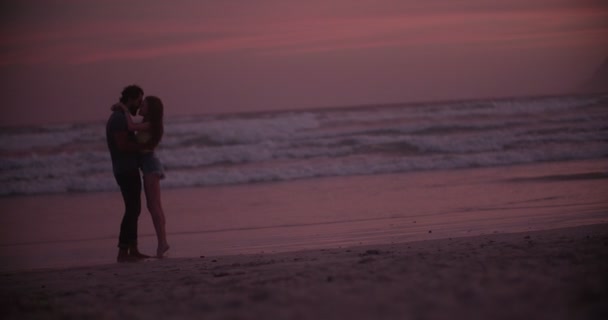 Szerető pár tengerparton naplementekor — Stock videók
