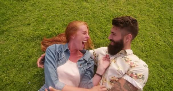 Пара хипстеров лежит на траве — стоковое видео