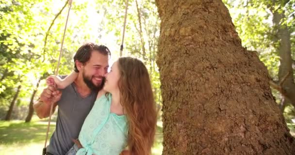 Couple assis ensemble sur une balançoire parc — Video