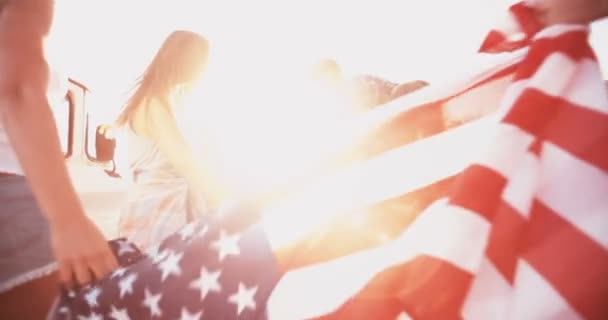 Tiener vrienden dragen een Amerikaanse vlag buiten — Stockvideo