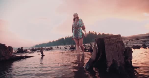 Boho girl walking through a shallow lake — Stock Video