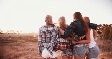 Genç kız gün batımına karşı karşıya