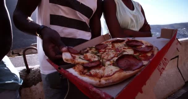Подросток берет кусочек пиццы — стоковое видео