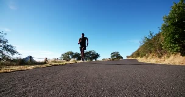 Atleta corriendo por un camino — Vídeos de Stock