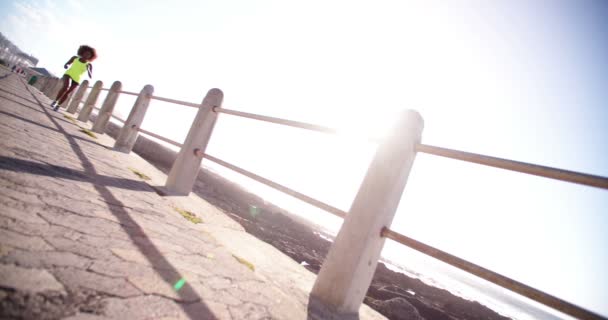 Athlète féminine courant le long de la plage — Video