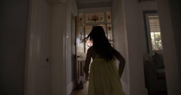 Petite fille courant joyeusement vers une porte d'entrée ouverte — Video