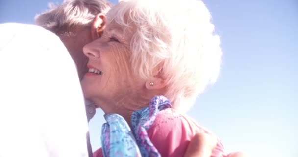 Loving elderly man kissing his wife at the beach — Stock Video