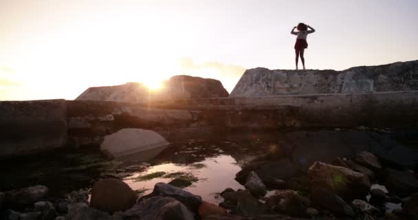 Mädchen tanzt auf Felsen am Meer — Stockvideo