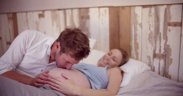 Çift mutlu bir şekilde yan yana yatakta yatarken bebek bekliyor — Stok video