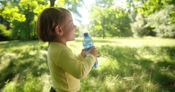 Enfant tenant une bouteille d'eau — Video