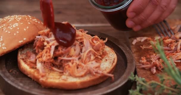 Salsa va a una deliciosa hamburguesa de cerdo tirada — Vídeos de Stock