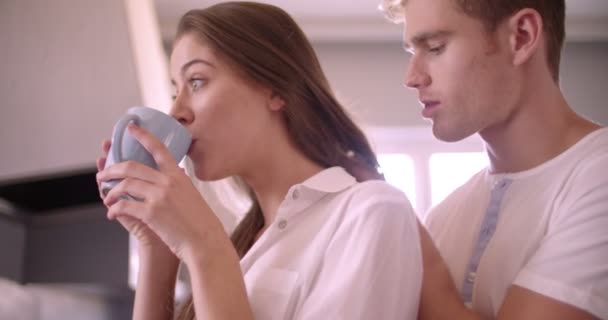 Guy liefdevol zoenen zijn vriendin in hun keuken — Stockvideo