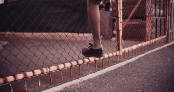Trespassing Afro grunge dziewczyna wspinaczka a ogrodzenie — Wideo stockowe