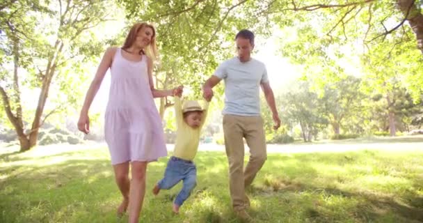 Padres balanceando a una niñita — Vídeos de Stock