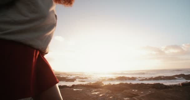 Κορίτσι στέκεται πάνω σε βράχια στην παραλία — Αρχείο Βίντεο