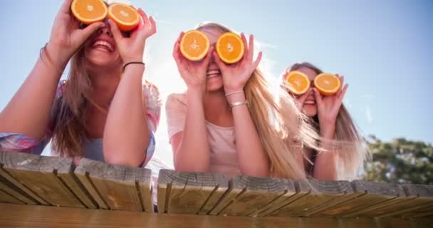 Adolescente menina amigos segurando laranjas para os olhos — Vídeo de Stock