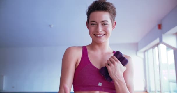 Adolescente chica celebración dumbbells — Vídeo de stock