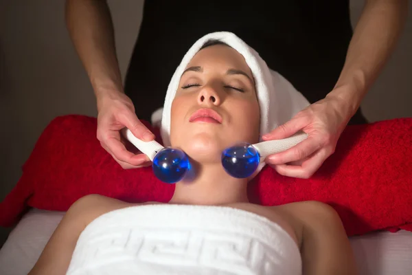 Jovem mulher no spa tendo massagem facial — Fotografia de Stock