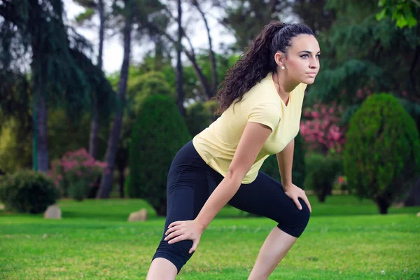 Deportiva estirando piernas en parque de verano — Foto de Stock