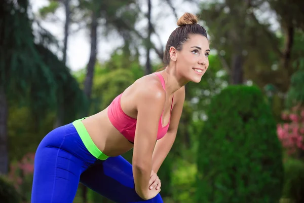 Mujer joven estirándose antes de correr en el parque — Foto de Stock