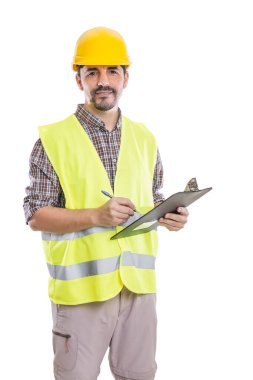 Kasklı ve sarı yansıtıcı yelekli erkek müteahhit beyaz arka plandaki kameraya bakarken pano ve yazıyla ayakta duruyor.