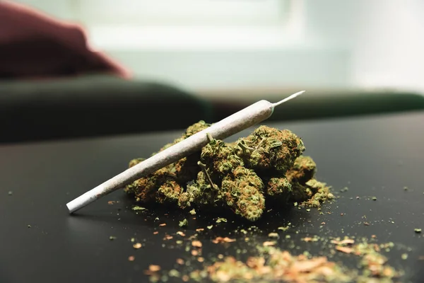 CBD ou THC bourgeons de cannabis et un joint sur une table — Photo