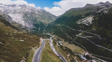 Dağlarla çevrili İsviçre Alplerinde dolambaçlı bir yol
