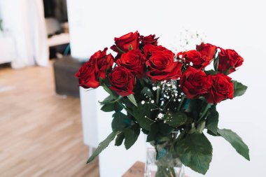 Vazoda beyaz çiçekli kırmızı güller - ev dekorasyonu