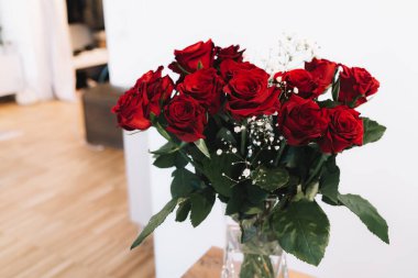 Vazoda beyaz çiçekli kırmızı güller - ev dekorasyonu