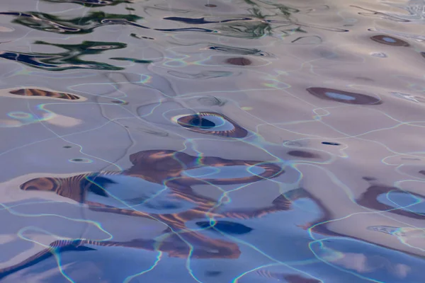 Wavy water surface in a fountain in blue tones