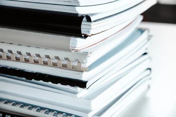 Stack of reports lies on a desk ready for review — Stock Photo, Image