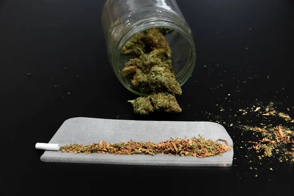 Bourgeons de cannabis dans un bocal et autres ustensiles de fumage — Photo