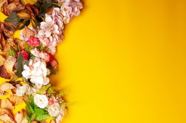 Çiçek ve yaprakların sarı arka planlı düğün davetiyesi sol tarafta.