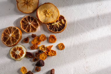 Detaylı kurutulmuş meyve, elma, limon, mandalina, üzüm, beyaz arka planda altın çilekler