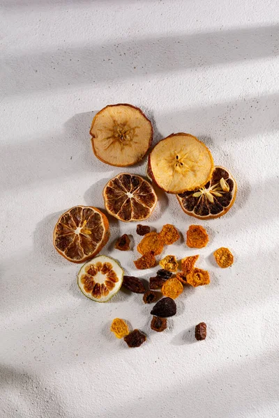 top view of dehydrated fruit, apple, lemon, tangerine, grapes, golden berries on white background