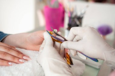 Profesyonel manikürcü müşterinin tırnaklarını törpülüyor, kişisel bakım konsepti