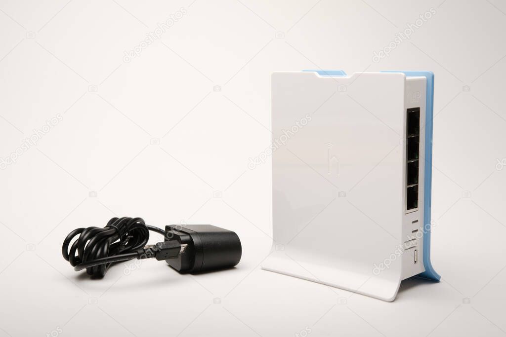 Machachi, Ecuador - July 06, 2021: Mikrotik hAP lite Rb941-2nd-tc Router with voltage adapter, isolated on white