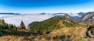Allgaeu Alpleri 'nin bulut kaplı manzaralı vadileri ve orman yamaçlarını ortaya çıkaran yüksek irtifalı tepe yürüyüşünün çarpıcı panoramik görüntüsü.