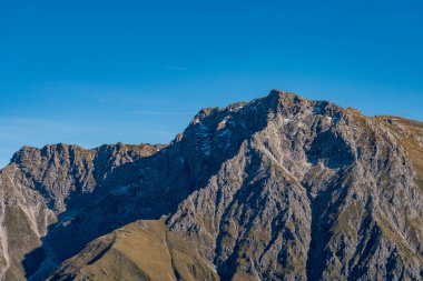 Allgaeu Alpleri 'nde manzaralı tepe ve vadileri gösteren, dağ sırtlarında yapılan bir sonbahar yürüyüşünün dingin güzelliğini yakala.