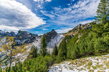 Fuessener Joechle 'den Grosse Schlicke zirvesine nefes kesici bir sonbahar yürüyüşü parlak mavi gökyüzü altında canlı dağ havası ve canlı yaprakları yakalıyor.
