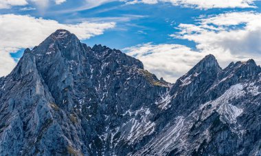 Engebeli alp zirvelerinin nefes kesici panoramik manzarası serin sonbahar güneşiyle yıkanarak Fuessener Joechle 'den Grosse Schlicke' ye kadar uzanan manzaralı yürüyüşte dinginlik ve macera uyandırır.