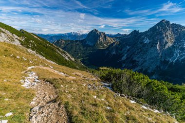 Manzaralı Fuessener Joechle yolu boyunca nefes kesici bir sonbahar yürüyüşü altın yamaçlar, engebeli zirveler ve berrak gökyüzü altında sakin dağ manzaraları sergiliyor.