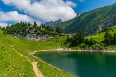 Sakin bir dağ yürüyüşü engebeli uçurumlarla çevrili el değmemiş bir dağ gölüne ve İsviçre Alpleri 'ndeki Appenzell yakınlarında barış ve macera çağrıştıran parlak gökyüzünün altında yemyeşil bir yeşilliğe götürür.