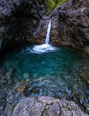 Görkemli bir şelale, Avusturya 'nın nefes kesen Gadental Vadisi' nde barış ve doğa harikası uyandıran engebeli kaya oluşumlarıyla çevrili sakin bir havuza zarifçe dalıyor.