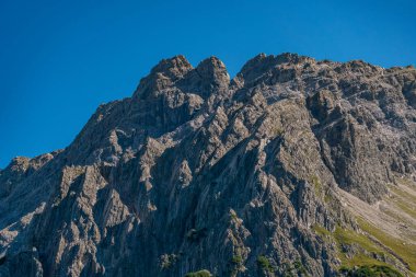 Berrak gökyüzünün altındaki engebeli dağ zirvelerinin nefes kesici manzarası Avusturya 'da dehşet ve sükuneti çağrıştırıyor.