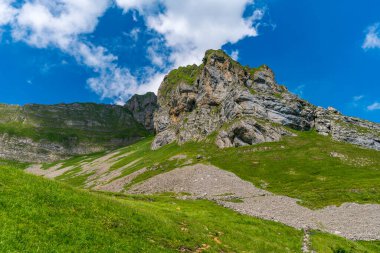 Nefes kesici bir dağ yürüyüşü dramatik uçurumlar ve parlak mavi gökyüzünün altında dingin yeşil çayırlar sergiliyor macera ve sükuneti çağrıştırıyor.