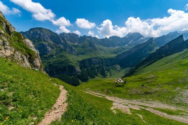 Nefes kesen bir dağ yürüyüşü canlı yeşil çayırlar, engebeli patikalar ve parlak gökyüzünün altında yükselen zirveler sükunet ve macerayı çağrıştırır.