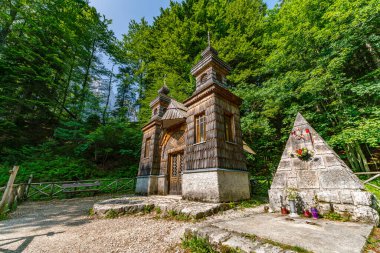 Sloven Triglav Ulusal Parkı 'nda huzur ve tarihi cazibeyi uyandıran canlı yeşilliklerle çevrili sakin bir ahşap şapel.