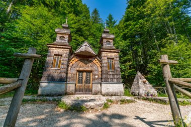 Yoğun yeşilliklerle çevrili tarihi bir kilise doğal güneş ışığı altında zamansız sükunet ve kültür mirasını anımsatıyor.
