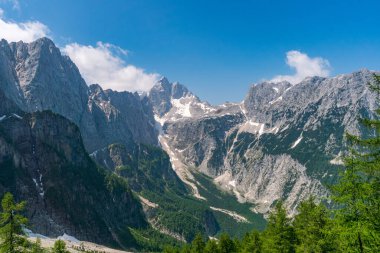 Pürüzlü dağların ve kar kaplı tepelerin nefes kesici panoramik manzarası Triglav Ulusal Parkları 'nda el değmemiş vahşi doğayı andıran altın güneş ışığı ve dinginliği uyandırıyor.